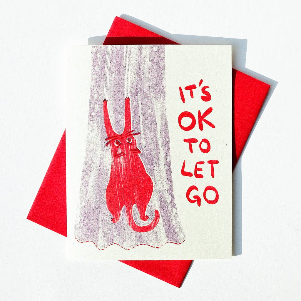 Greetings card with cream background with image of a red cat hanging on to a grey curtain with red text says, "It's one to let go". Red envelope included, 