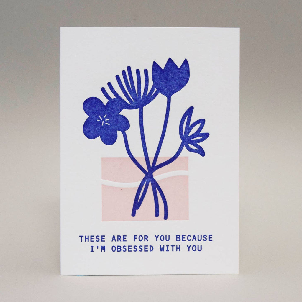 White background with image of bright blue flowers and pink vase. Blue text says, "These are for you because I'm obsesses with you". Envelope included.
