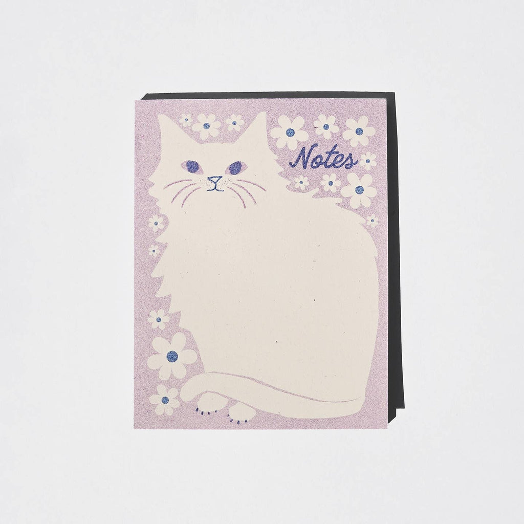 Note pad with ivory cat with area for writing notes and lavender background with white flowers with blue centers.