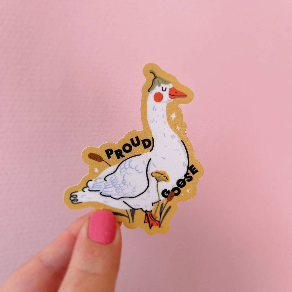 Decorative sticker in the image of white goose wearing a green leaf and black text says, "Proud goose". 