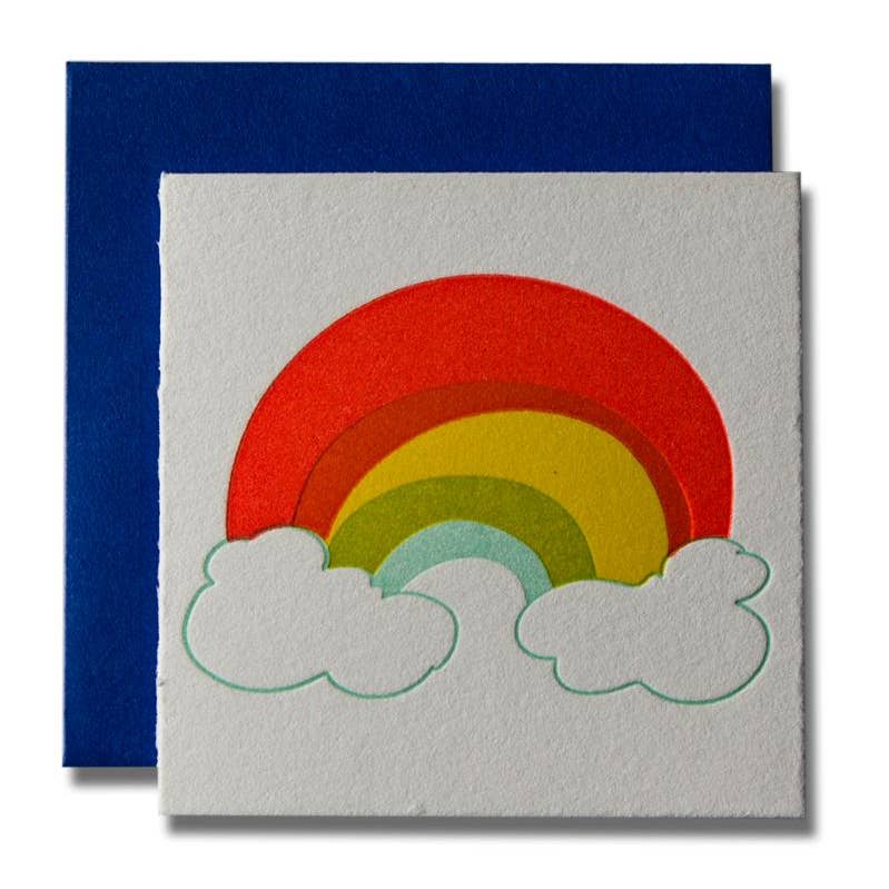 Ivory background with image of rainbow and clouds. Blue envelope included. 
