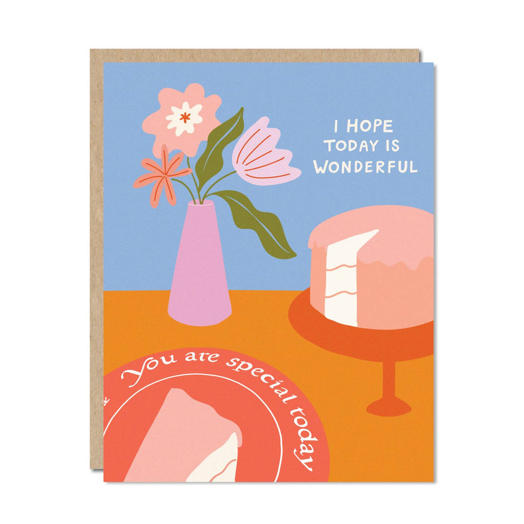 Blue and orange background with image of pink vase of flowers. Peach cake on cake stand and a red place with “You are special today” on rim. White text says, “I hope today is wonderful”. Kraft envelope is included. 
