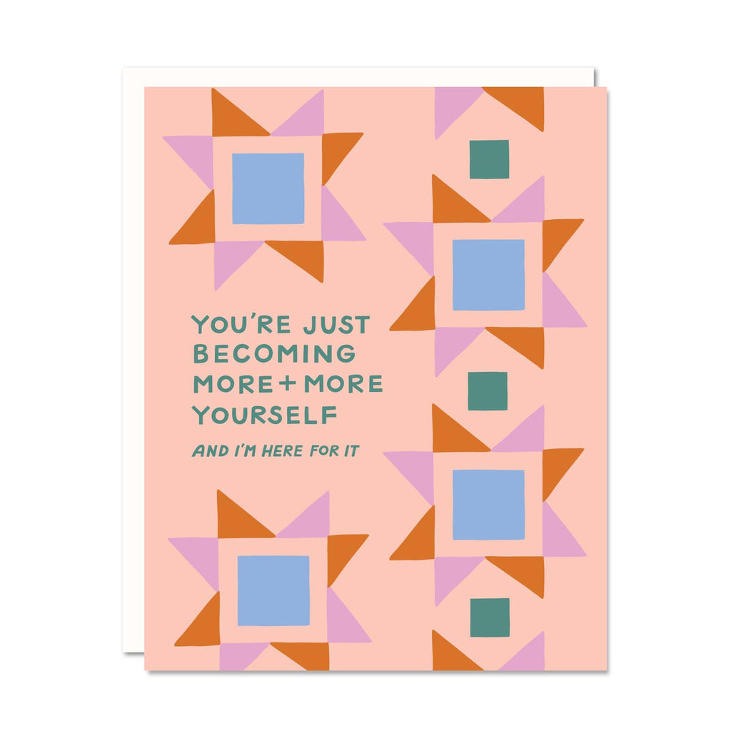 Greeting card with peach background and image of quilt squares in blue, rust and pink with green text says, "You're just becoming more + more yourself and I'm here for it". White envelope included. 