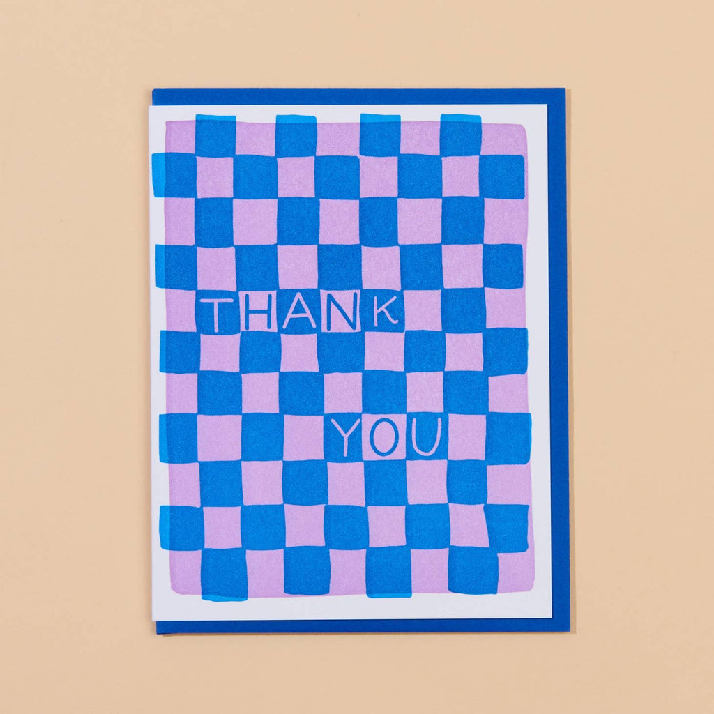 Image of card with blue and pink checkerboard pattern with blue and pink text says, "Thank you".  Blue envelope included. 