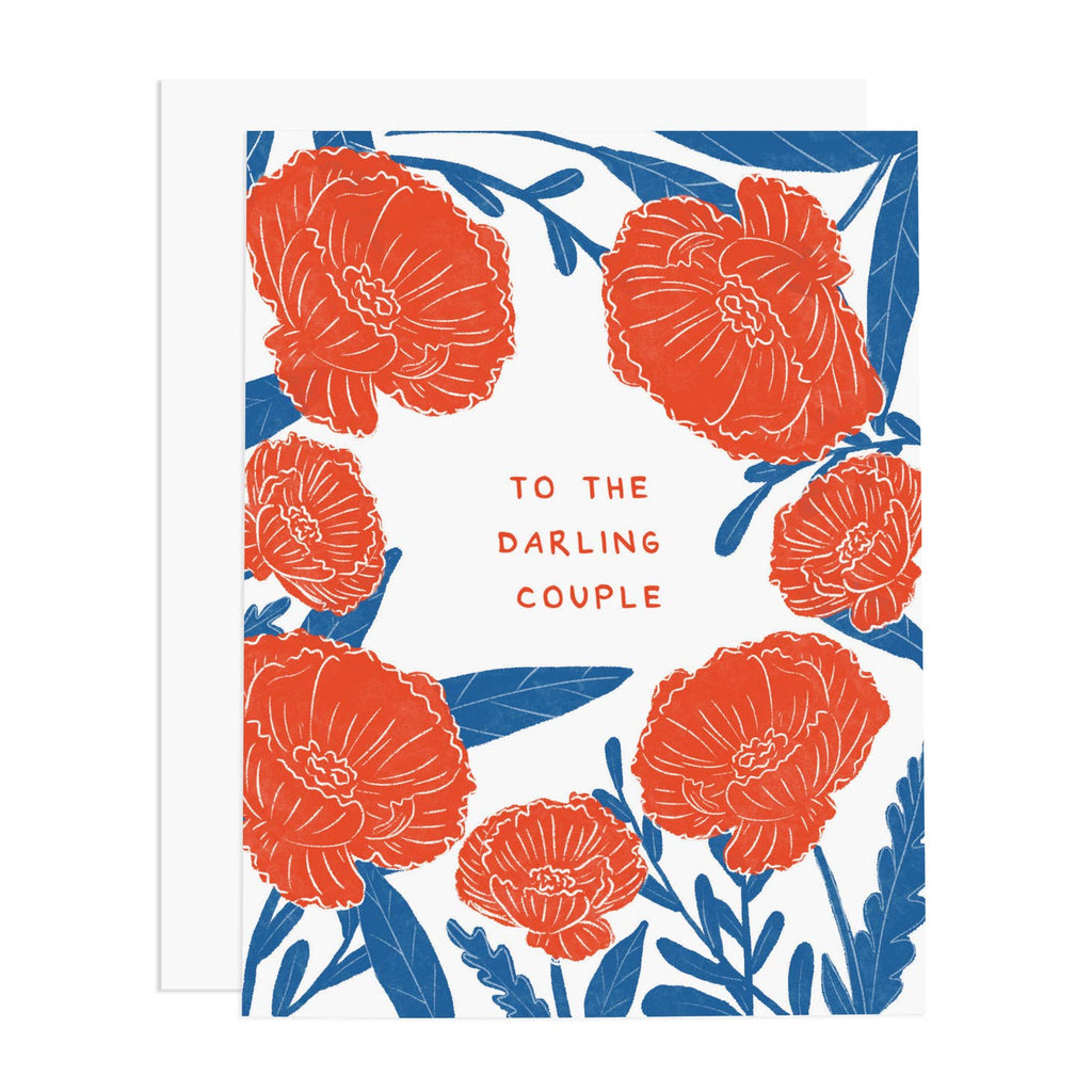Image of card with white background and red flowers with blue stems and leaves with red text says, “To the darling couple”. White envelope is included.     