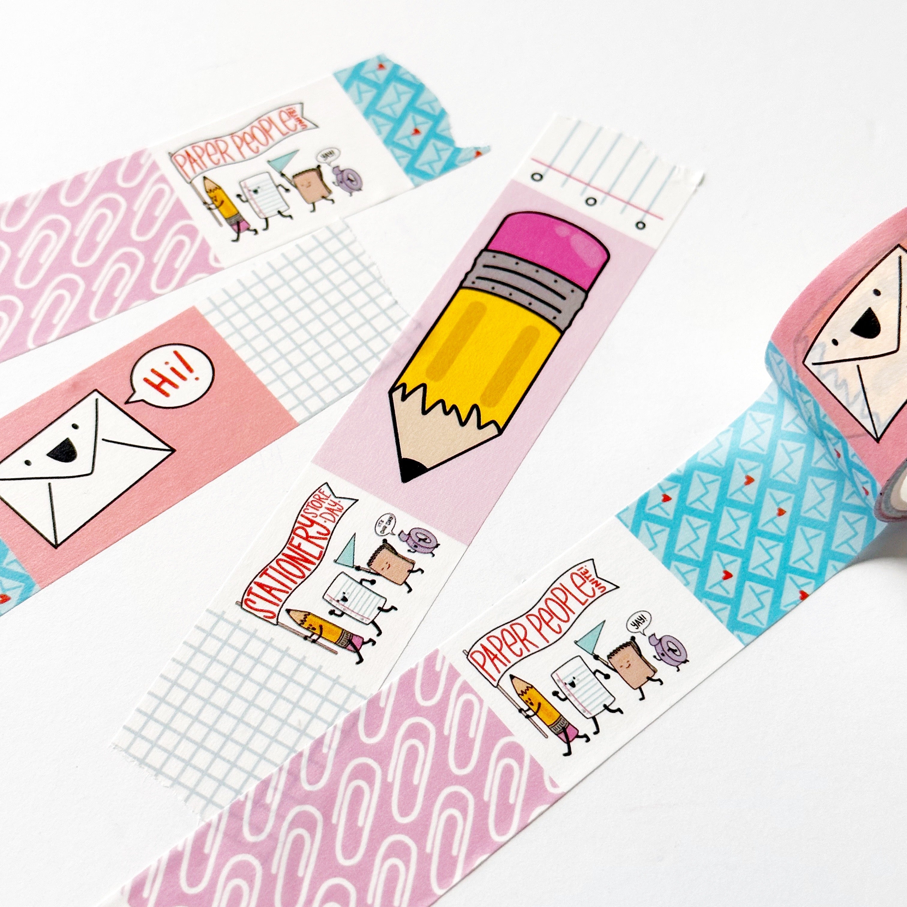 Image of stamp washi tape with images of yellow and pink pencil, pink background with white paperclips, blue and white striped and blue and white checked, pink background with white envelope saying "Hi".