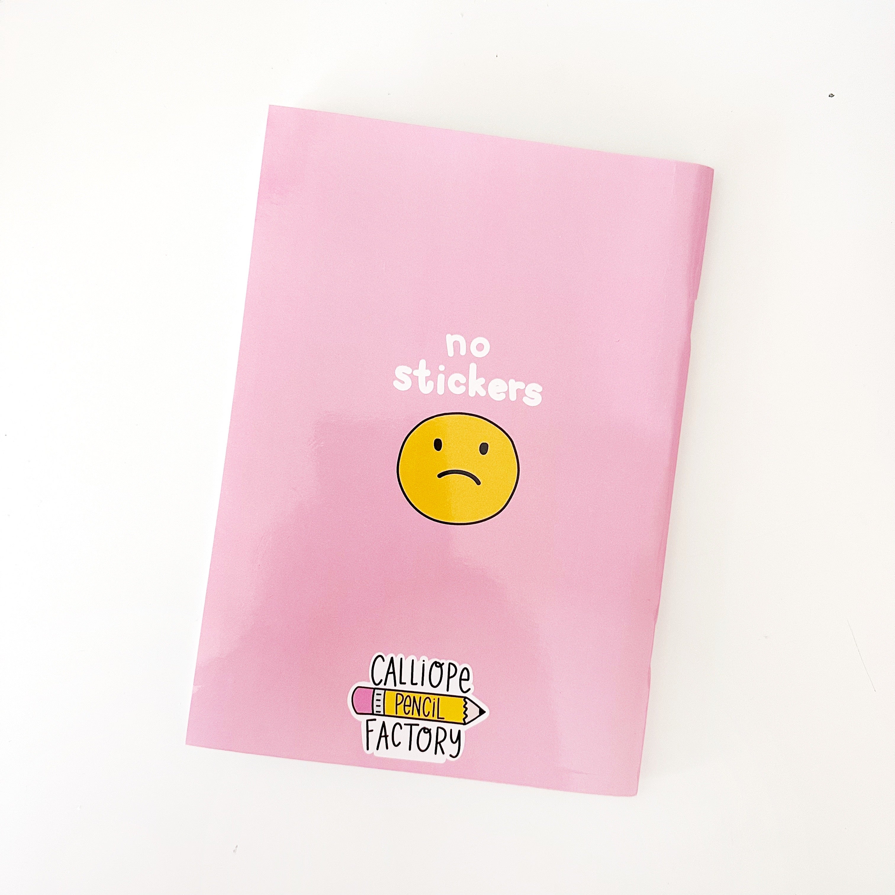 Image of back of book with pink background with image of a sad yellow sad face and white text says, "No stickers". 