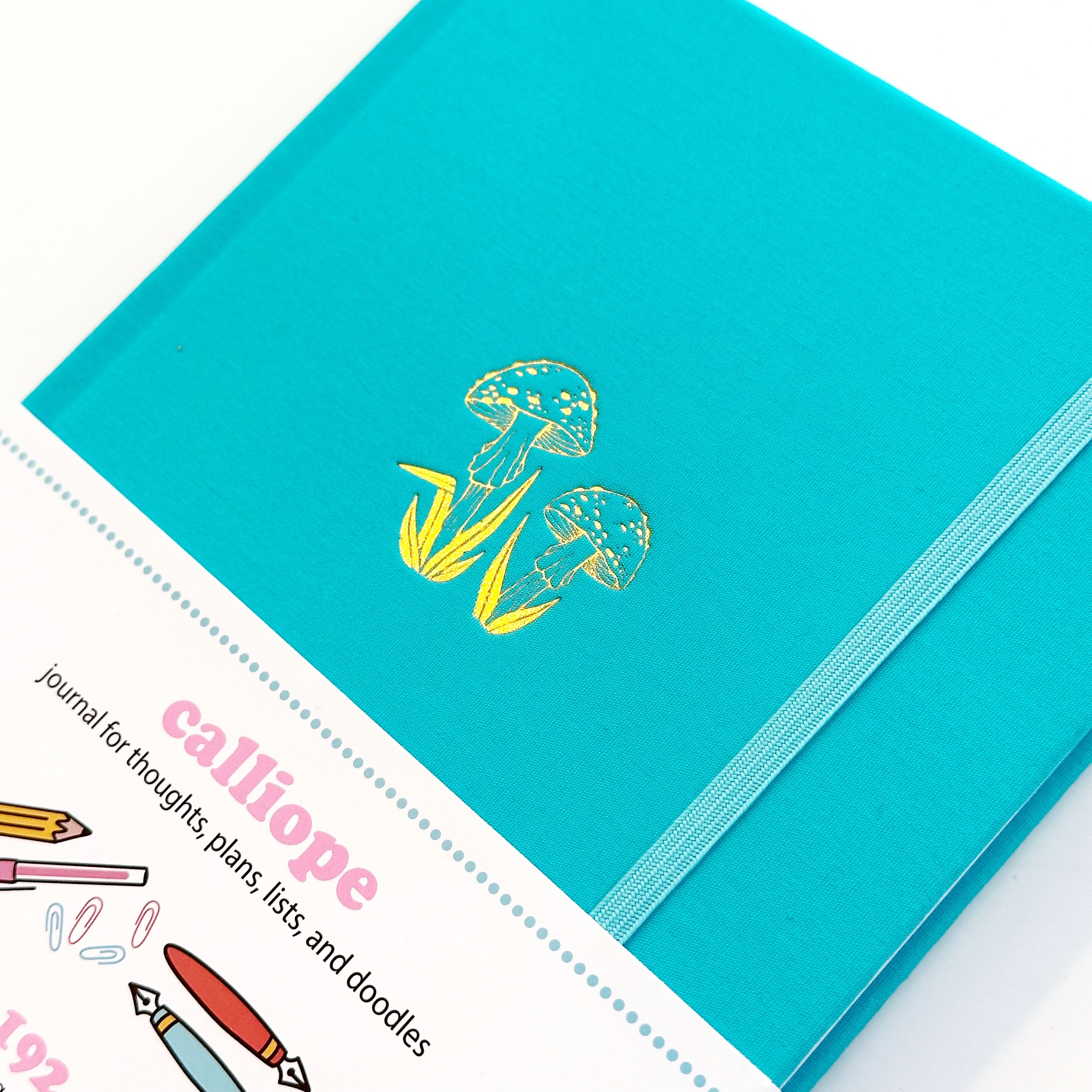 Image of teal journal with gold foil twin mushrooms. 
