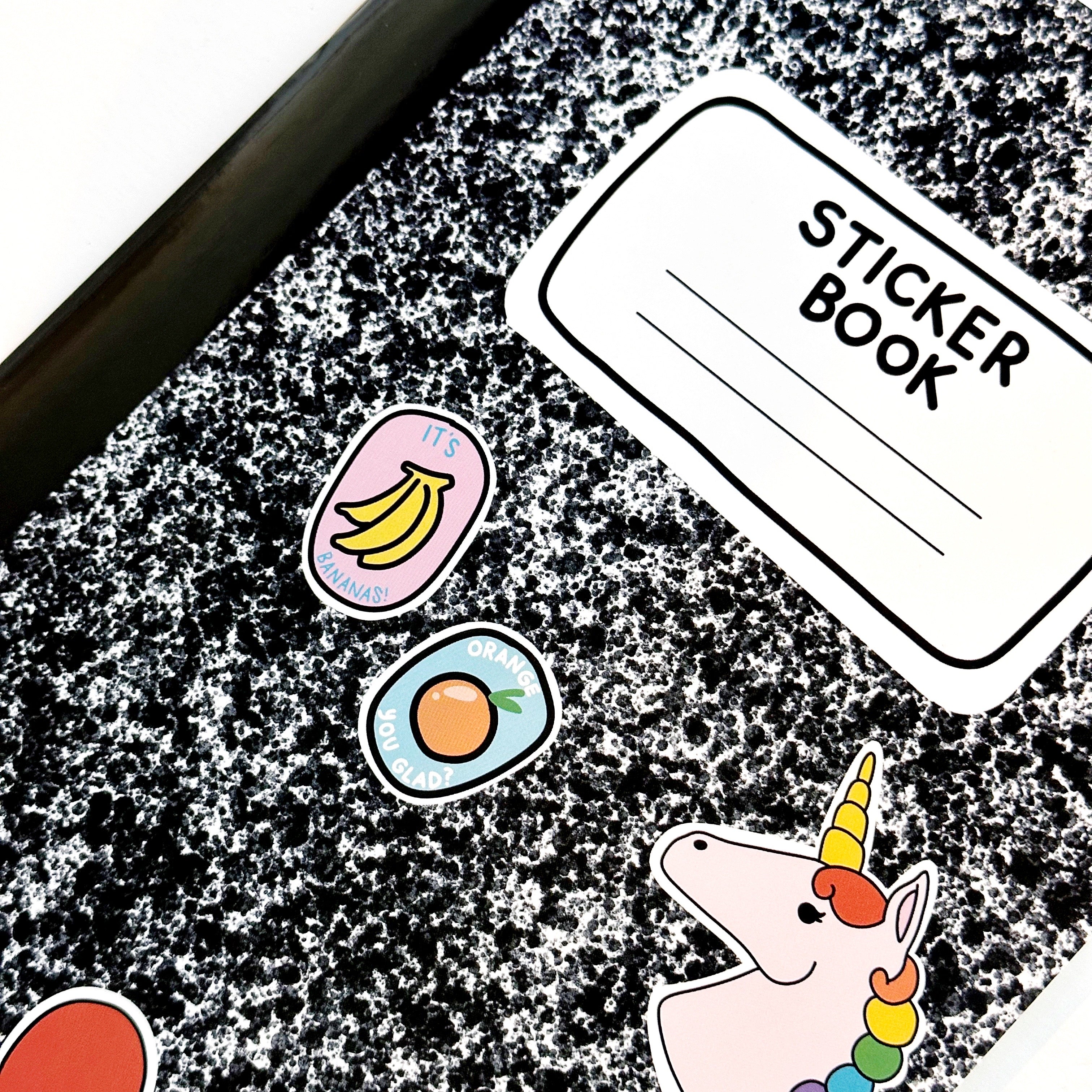 mage of black and white composition notebook as a sticker book with images of stickers on the front including a unicorn, heart, smiley face, orange and bananas with black text on white field says, "Sticker book" with lines for adding name."