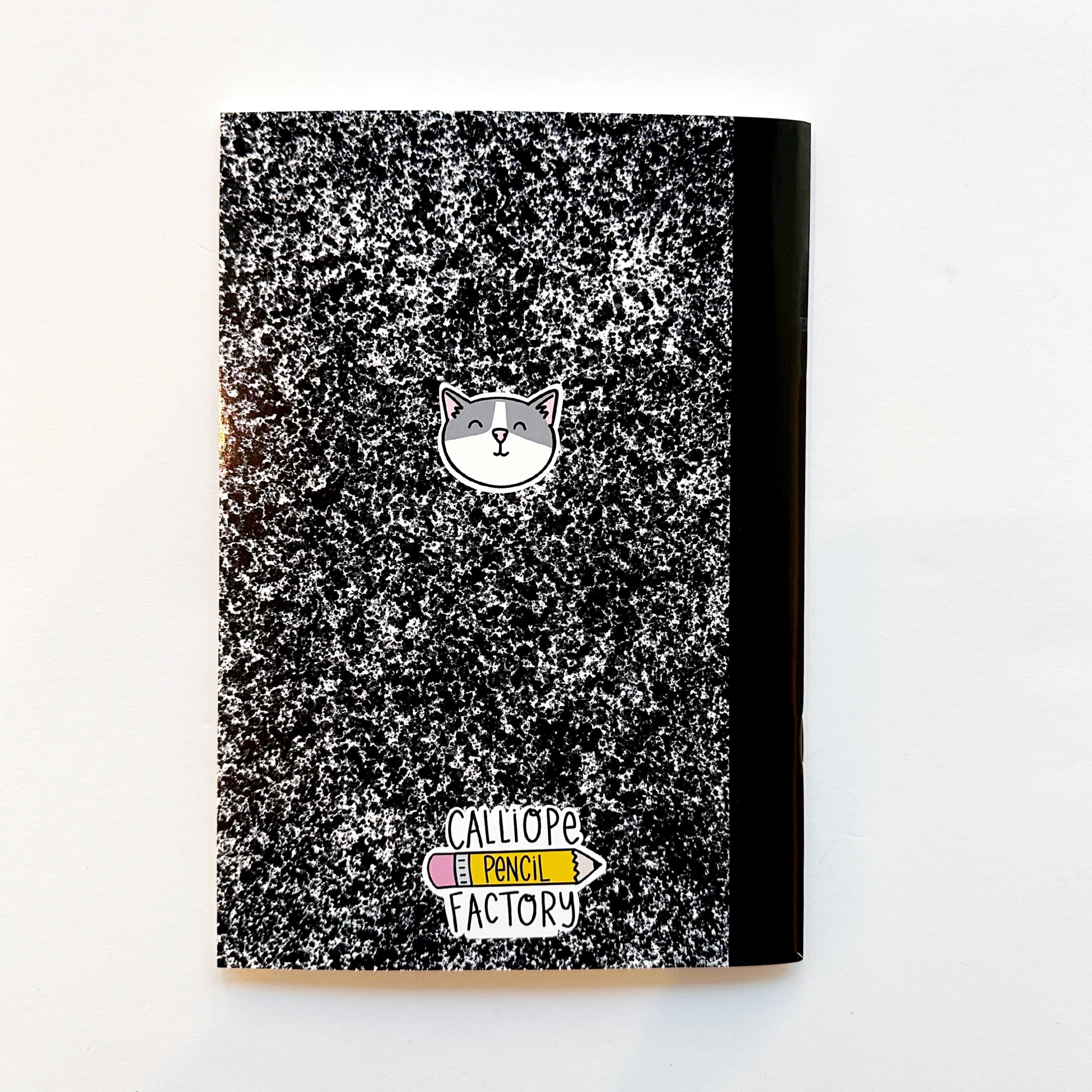 mage of black and white composition notebook as a sticker book with image of a grey and white cat face on back.