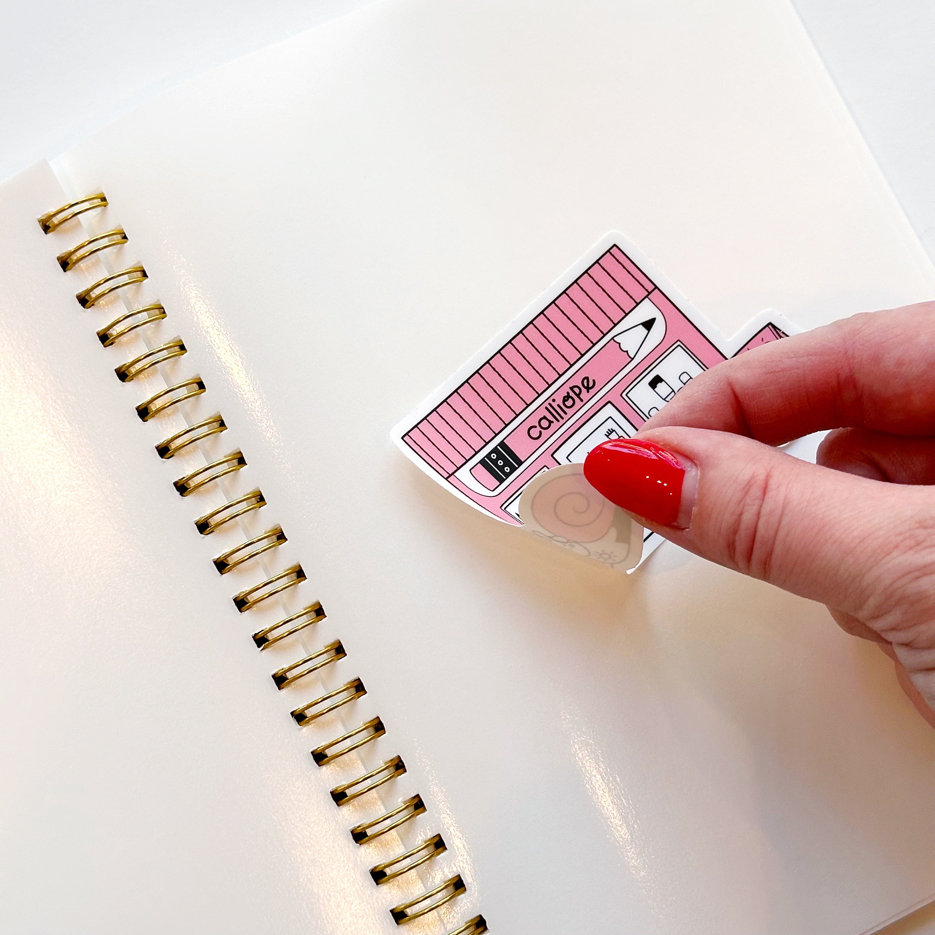 Image of blank page with sticker being laid onto page and lifted up. 