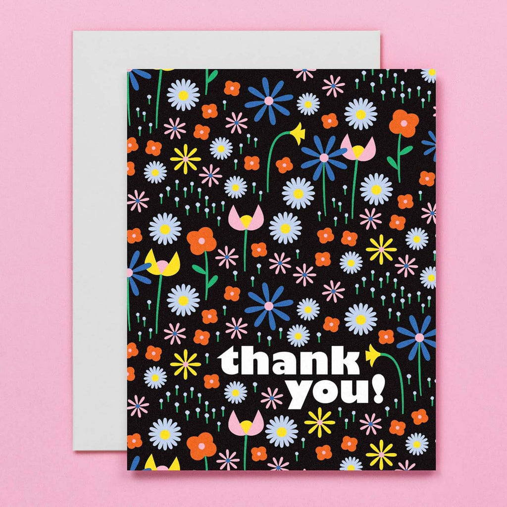 Black background with images of flowers in pink, blue, yellow, red and green with white text says, "Thank you!". White envelope included. 