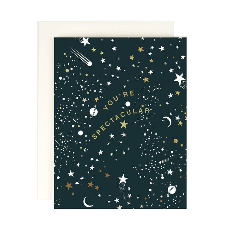 Black background with images of stars and moons with gold text says, "You're spectacular". Cream envelope is included. 