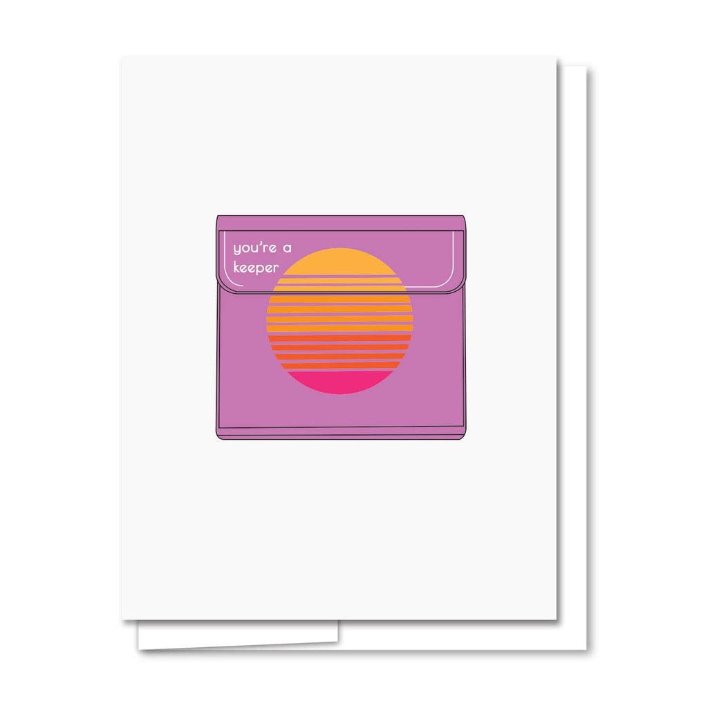 Greeting card with white background and image of a purple trapper keeper with a yellow, orange and red decoration and white text says, "You're a keeper". White envelope included.