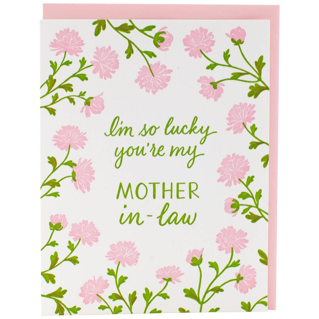 Greeting card with white background and pink mums with green stems and leaves. Green text says, "I'm so luck you're my Mother in Law". Pink envelope included. 