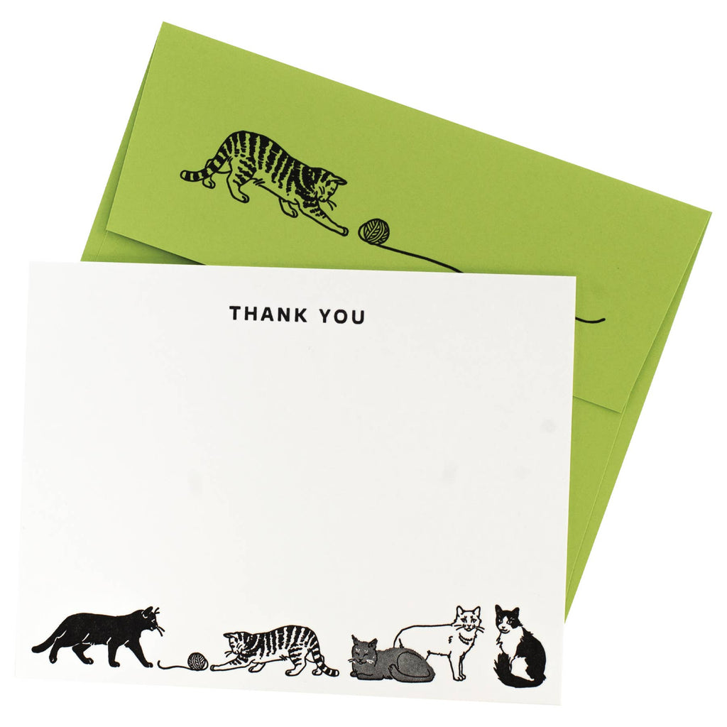Notecard with white background and images of black and white cats with yarn at bottom and black text says, "Thank you" at top of card. Apple green envelopes with image of black striped cat with ball of yarn on back flap. 