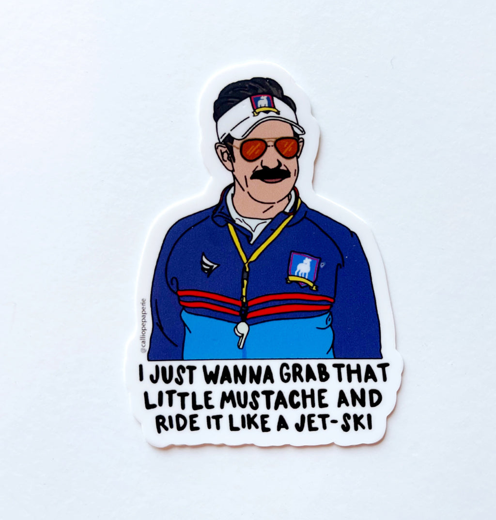 Image of Ted Lasso in sunglasses and a visor. Text underneath in black says "I just wanna grab that little mustache and ride it like a jet-ski"