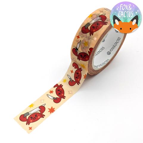 Image of peach tape with images of red crabs holding knives. 