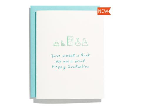 White card with teal text saying, “You’ve worked so hard. We are so proud. Happy Graduation!” Images of school supplies including a protractor, ruler, composition notebook and science beakers. A teal envelope is included.