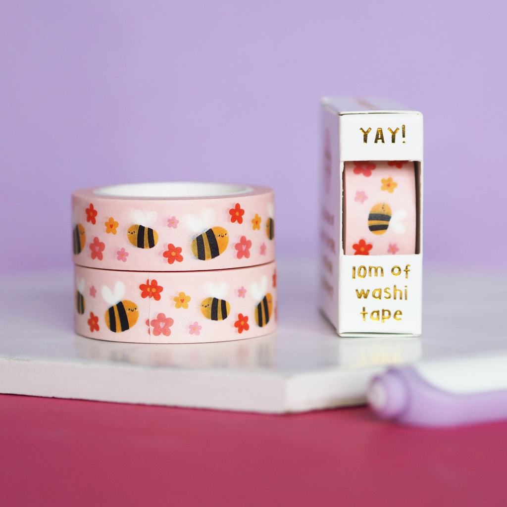 Decorative tape with light pink background with images of bumble bees and pink, yellow and red flowers.
