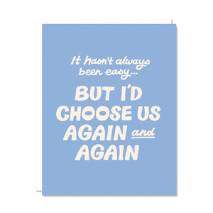 Greeting card with blue background and white text says, "It hasn't always been easy...but I'd choose us again and again". White envelope included. 