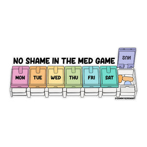 Decorative sticker in the image of a daily pill dispenser in rainbow colors with black text says, "No shame in the med game" and "mon, tue, wed, thu,fri, sat" on each section. 