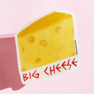 Decorative sticker in the image of a wedge of cheese with red text says, "Big cheese". 