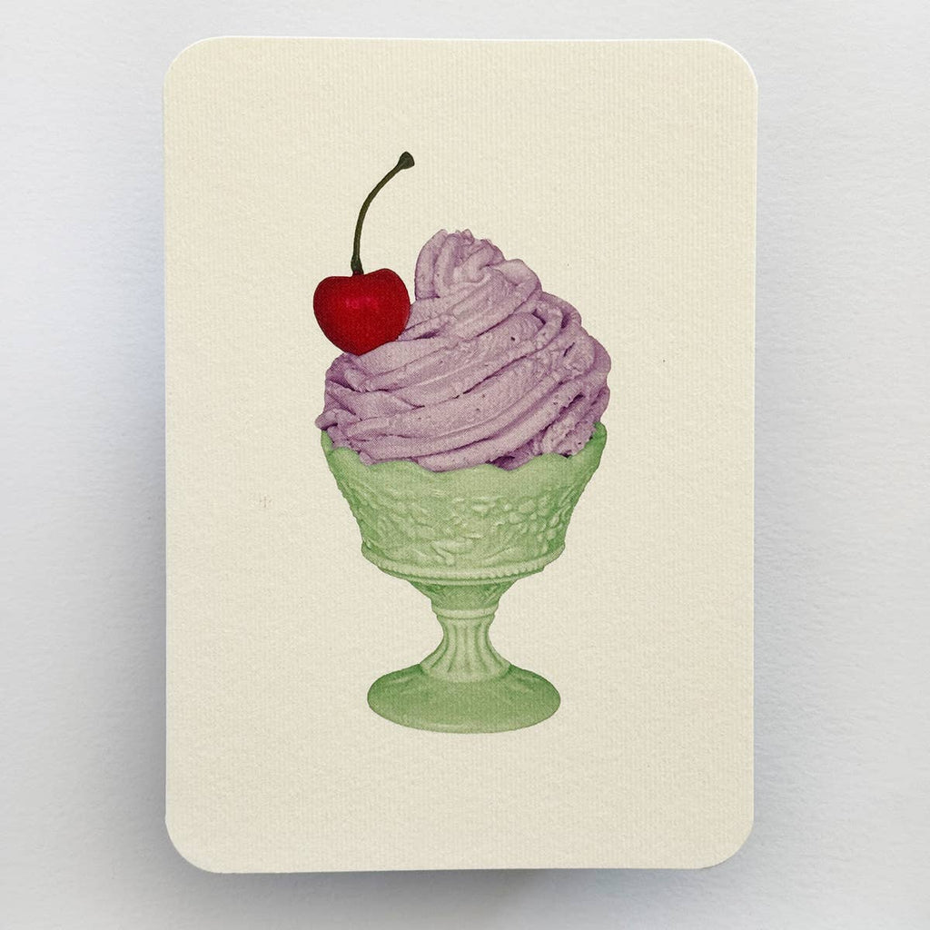 Greeting card with cream background and image of lavender Chantilly cream dessert in green glass with red cherry on top. Envelope included.