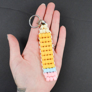 Image of pencil keychain made from beads in pink, yellow, tan and blue with metal ring. 