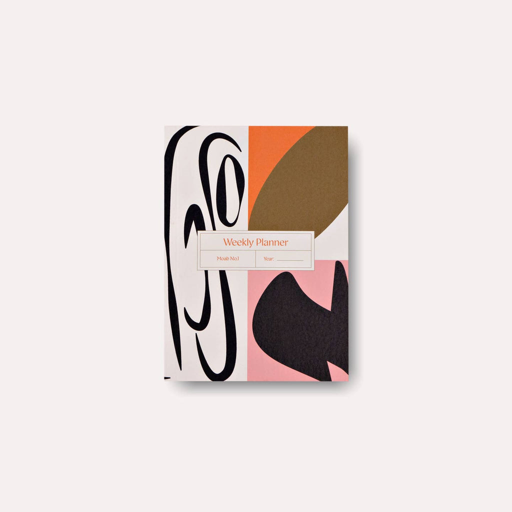 Planner cover with geometric patterns in black, cream, orange, brown and pink. 