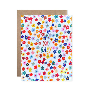 Greeting card with white background and images of multicolored flowers and text says, "Yay baby". Kraft envelope included.