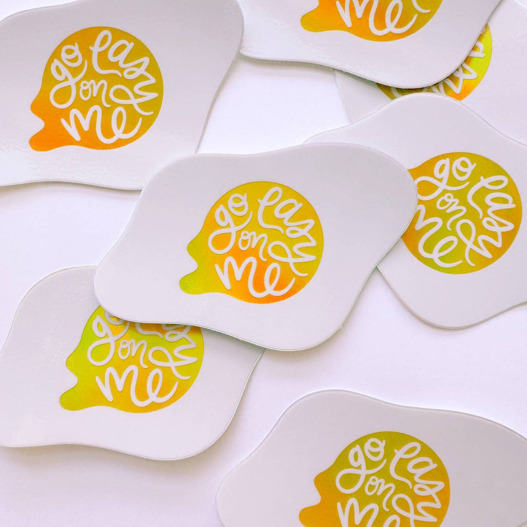 Decorative sticker in the image of an over easy egg with white text on yellow yolk says, "Go easy on me". 