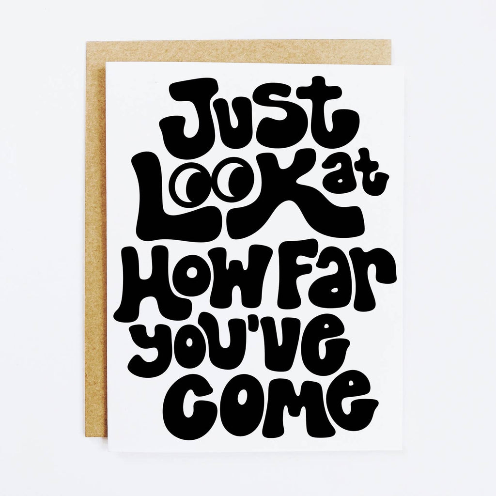 White background with black text says "Just look at how far you've come". Kraft envelope included. 