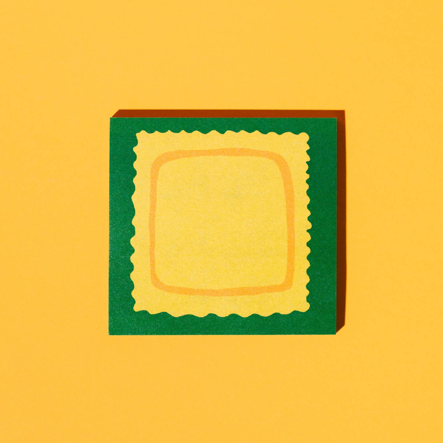 Sticky notepad with green background and yellow ravioli in center.