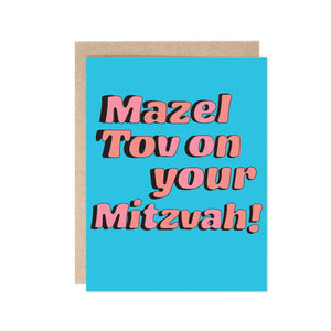 Greeting card with light blue background and pink text says, "Mazel Tov on your Mitzvah!". Kraft envelope included. 