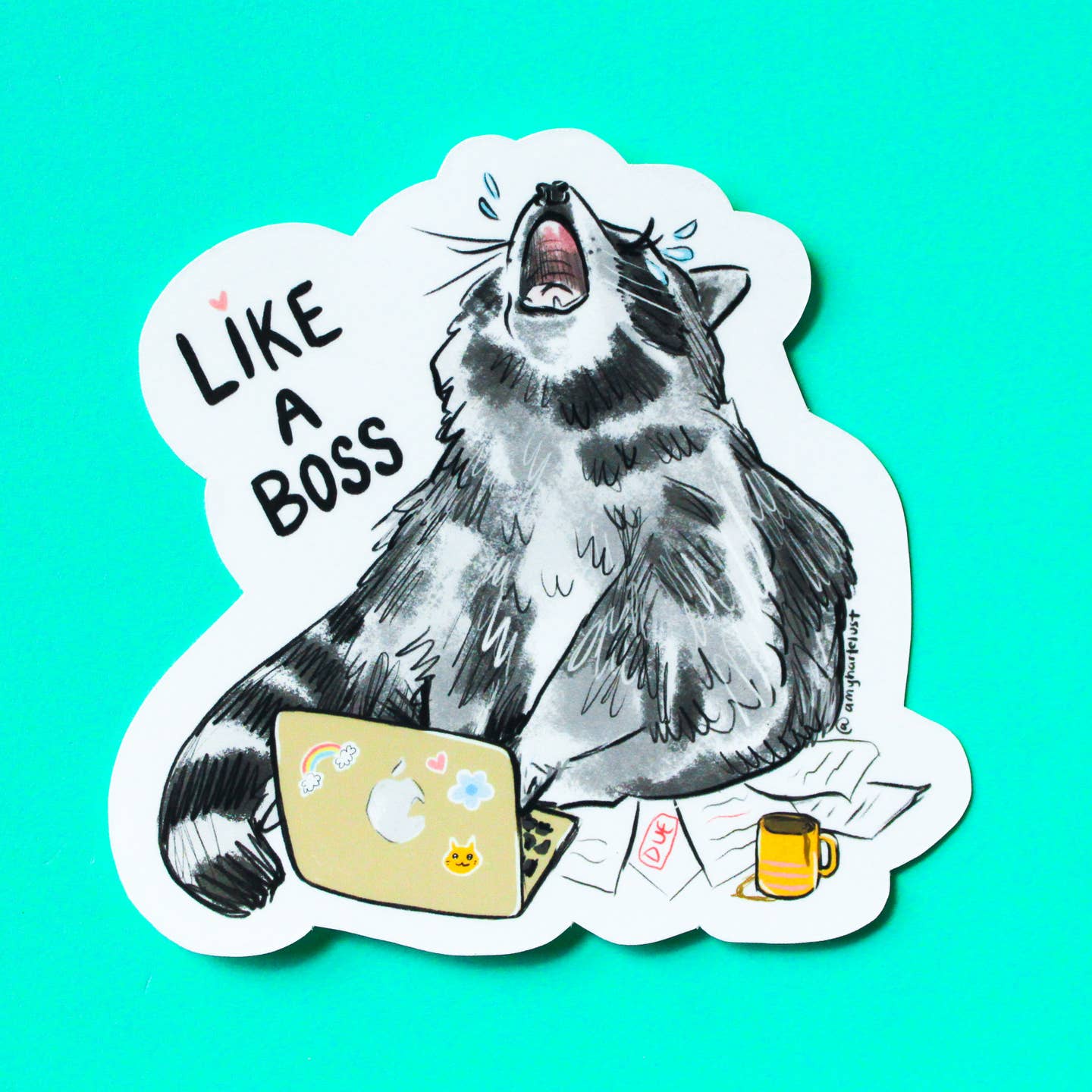 Decorative sticker with white background and image of a raccoon and a laptop with pile of papers and coffee mug. Black text says,  "Like a boss". 