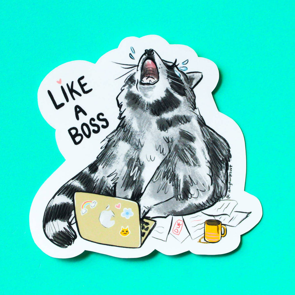 Decorative sticker with white background and image of a raccoon and a laptop with pile of papers and coffee mug. Black text says,  "Like a boss". 