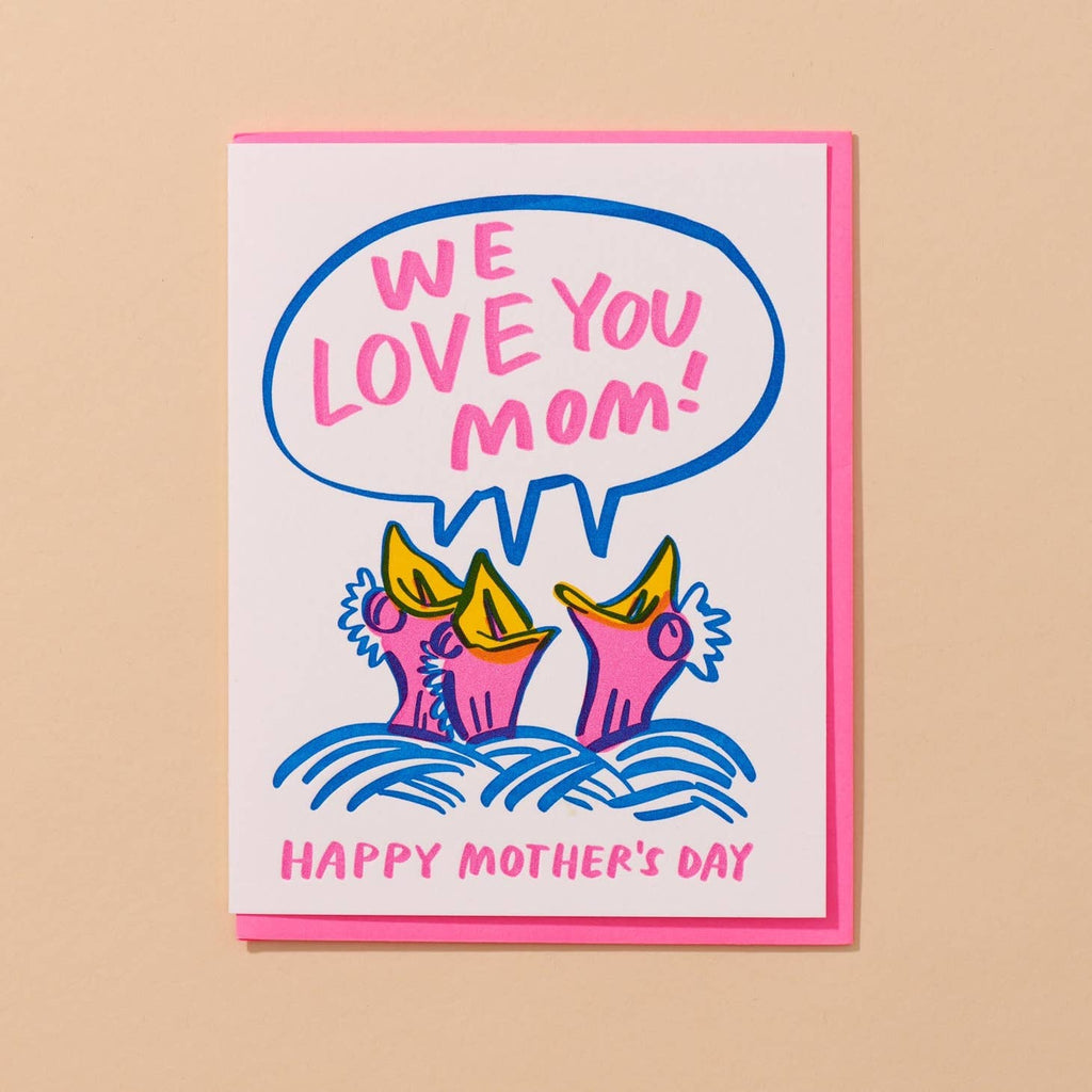 Greeting card with white background and image of three neon pink baby birds in a blue nest with neon pink text says, "We love you Mom!" and "Happy Mother's Day". Neon pink envelope included, 