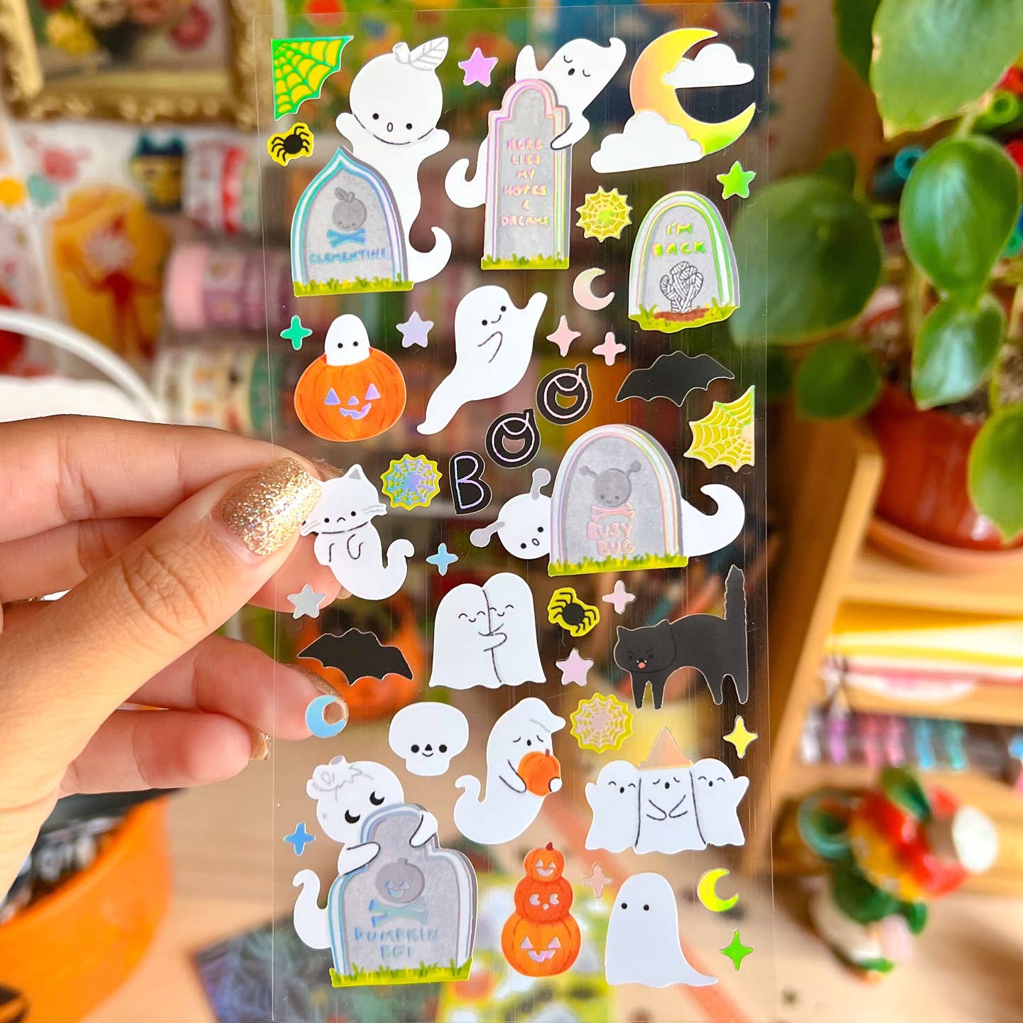 Decorative stickers with clear background and images of ghosts with gravestones in white and grey. 