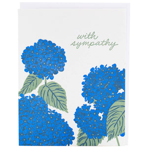 Greeting card with white background and image of blue hydrangea with green leaves and green text says, "with sympathy". White envelope included. 