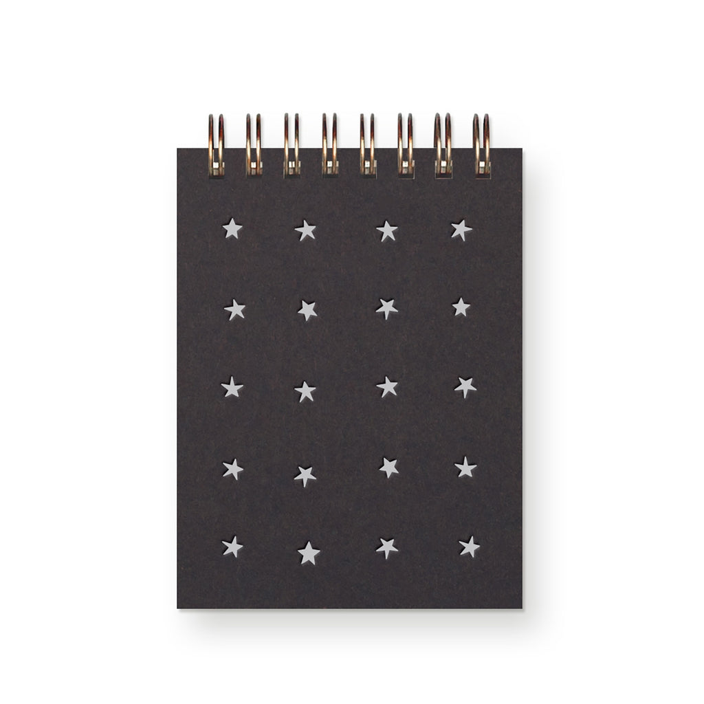 Pocket notebook with black cover with white stars in a grid pattern with a coiled binding at top. 