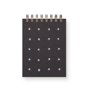 Pocket notebook with black cover with white stars in a grid pattern with a coiled binding at top. 