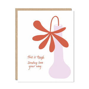 White background with image of a lavender vase with a red flower. Red text says, “This is tough. Sending love your way.” Kraft envelope is included.    
