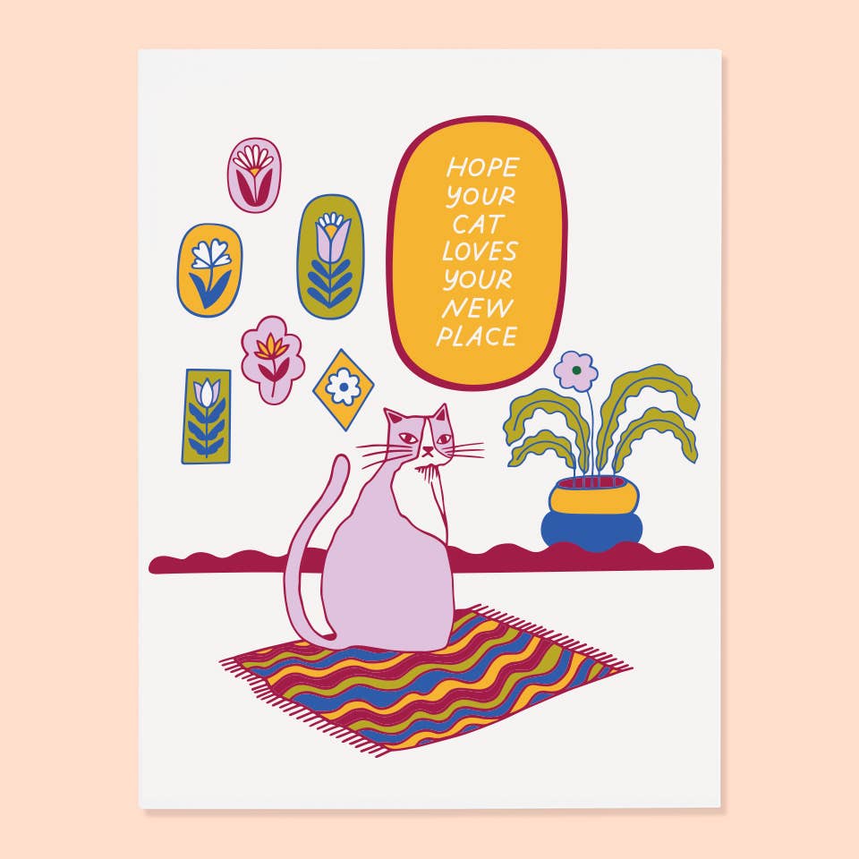 White background with image of a pink cat sitting on a rug with pictures of plants on the wall. A yellow oval with white text says, "Hope your cat loves your new place". White envelope included. 