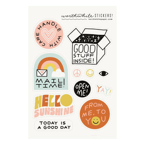 Image of sticker sheet with white background and images of stickers including box with "good stuff inside", pink circle with "handle with care", black circle with "Open me!", "hello sunshine". 