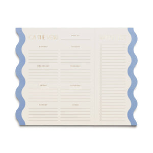 Notepad with cream background and blue wavy edges. Gold foil text says, "On the menu, Week of, Monday, Tuesday, Wednesday, Thursday, Friday, Saturday, Sunday, Other" with perforated list with gold foil text and lines, "Market list". 