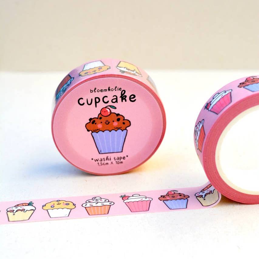 Image of roll of washi tape with a pink background and images of cupcakes in yellow, white, pink, brown and red. 