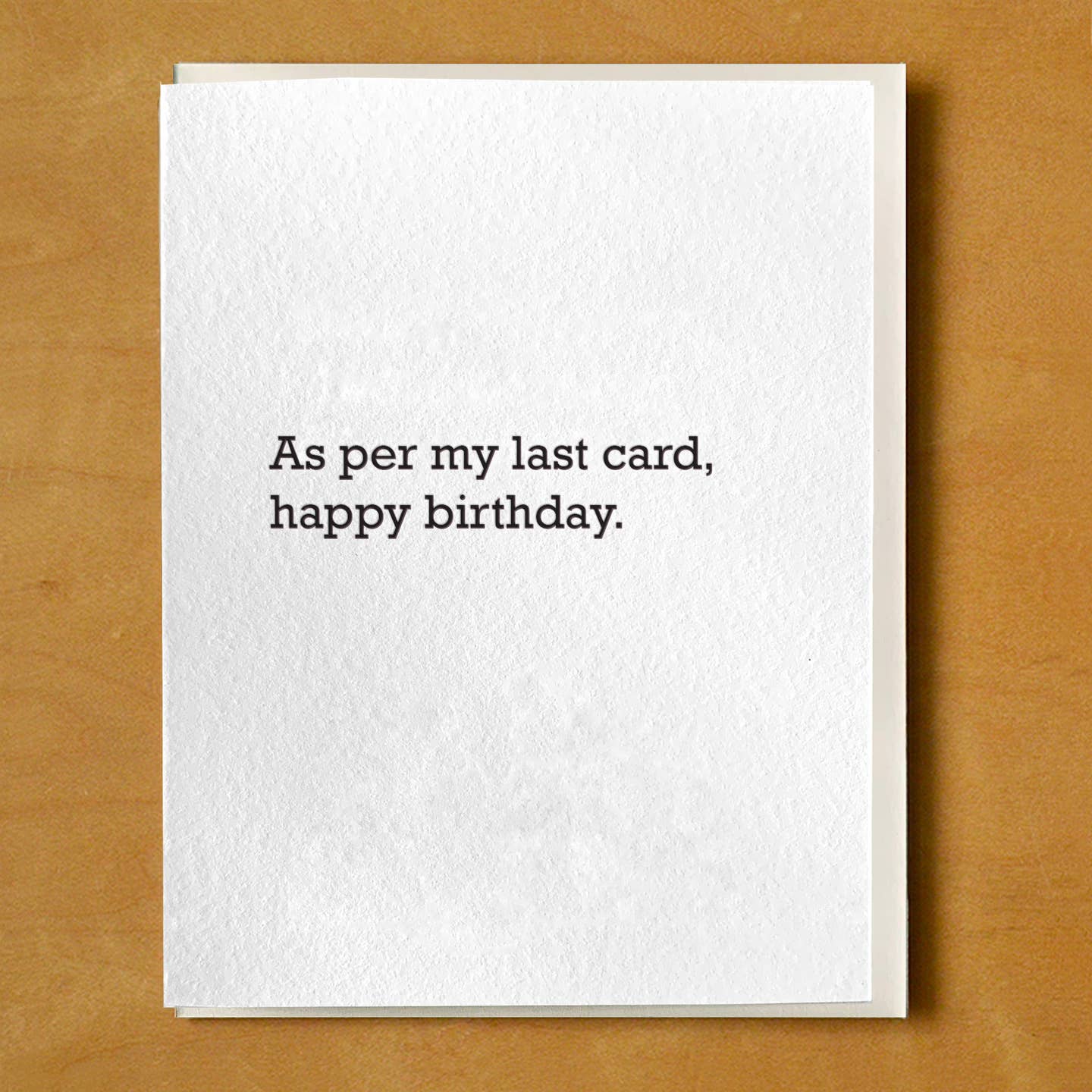 Greeting card with white background black text says, "As per my last card, happy birthday.". Envelope included. 