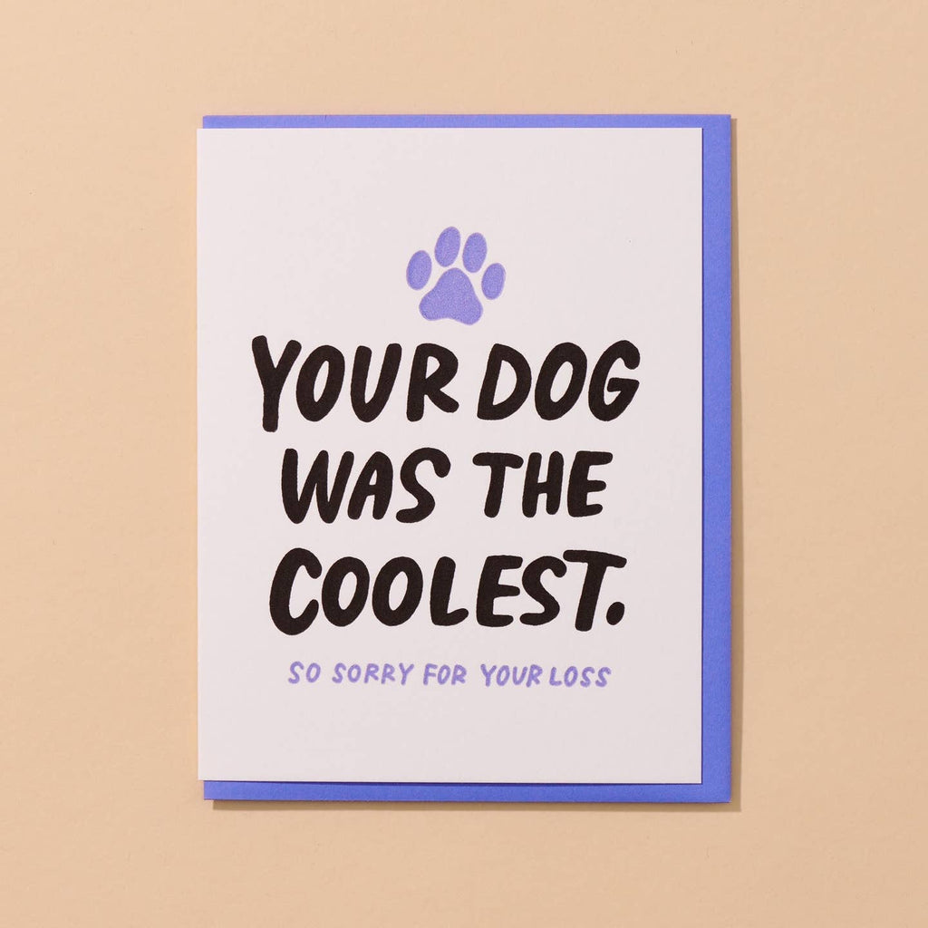 Greeting card with white background and black text says, "Your dog was the coolest." with lilac text says, "So sorry for your loss" and image of lilac paw print. Lilac envelope included. 