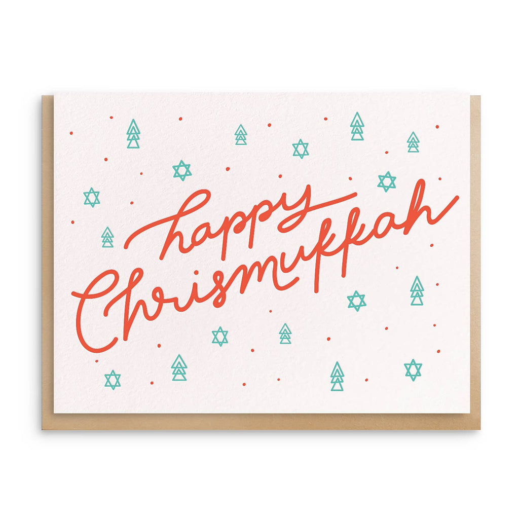 Greeting card with white background and images of trees and stars in green and red text says, "Happy Chrismukkah". Kraft envelope included.